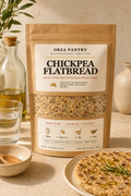 ORZA Pantry mix pouch beside olive oil, bowl and baked flatbread